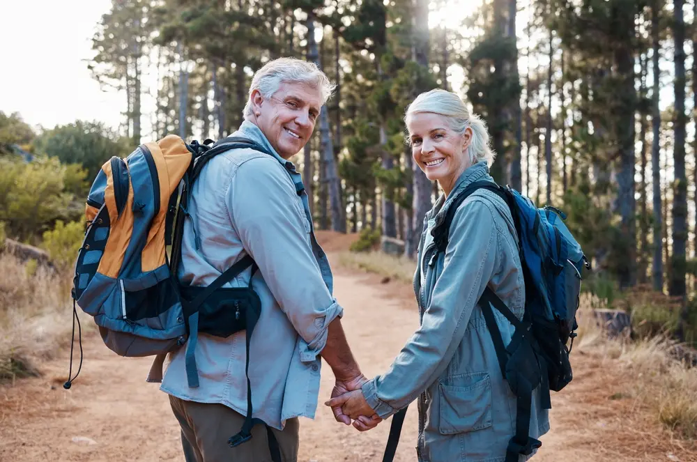 Old couple holding hands while hiking and enjoying nature