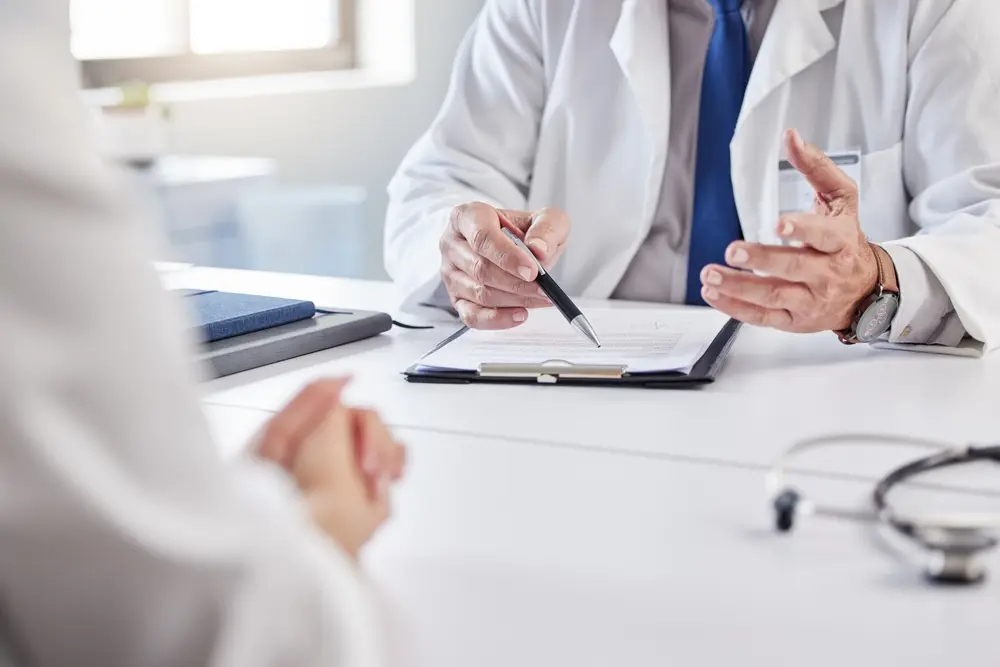 Doctor and patient discussing medical consultation while reviewing clipboard